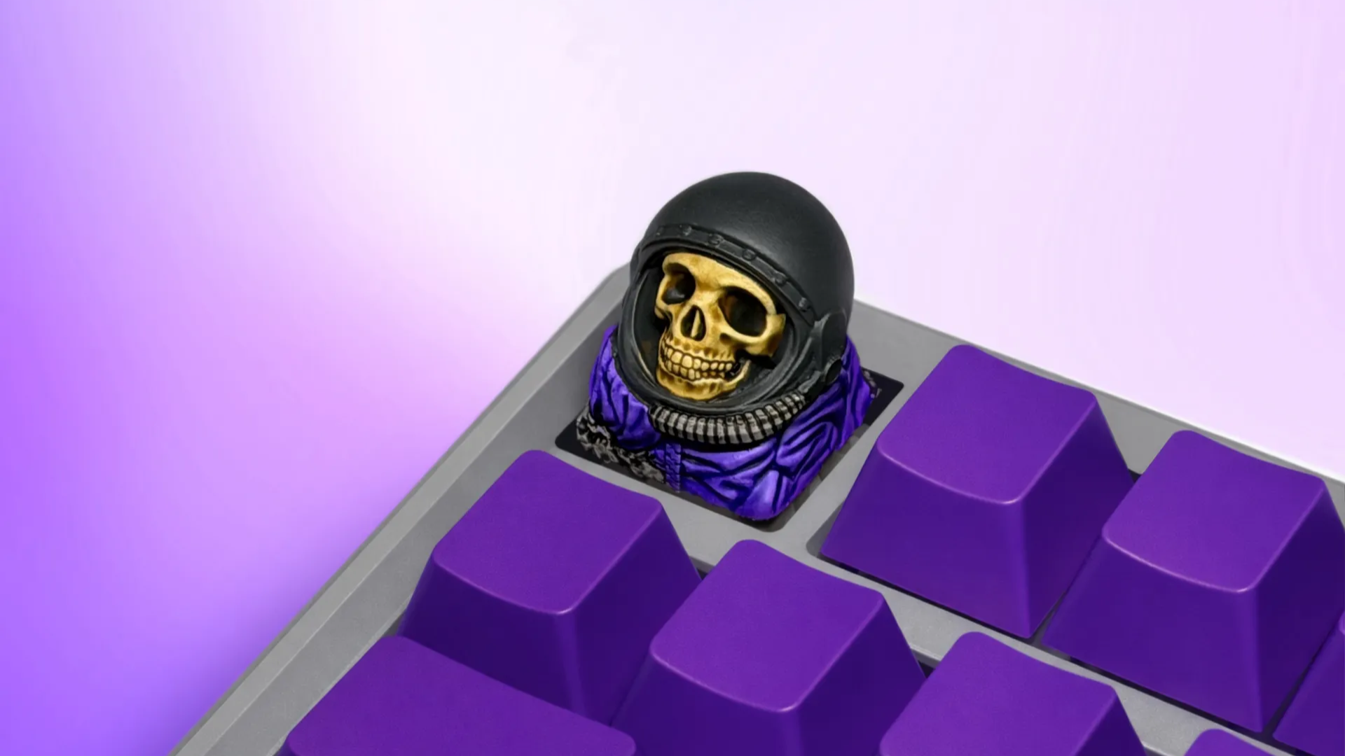 XIIX Astronaut artisan keycap on a purple mechanical keyboard, angled view
