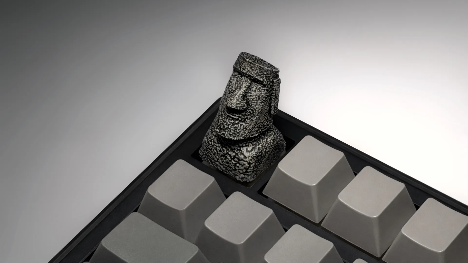 XIIX Moai Ancient Stone artisan keycap on a grey mechanical keyboard, angled view
