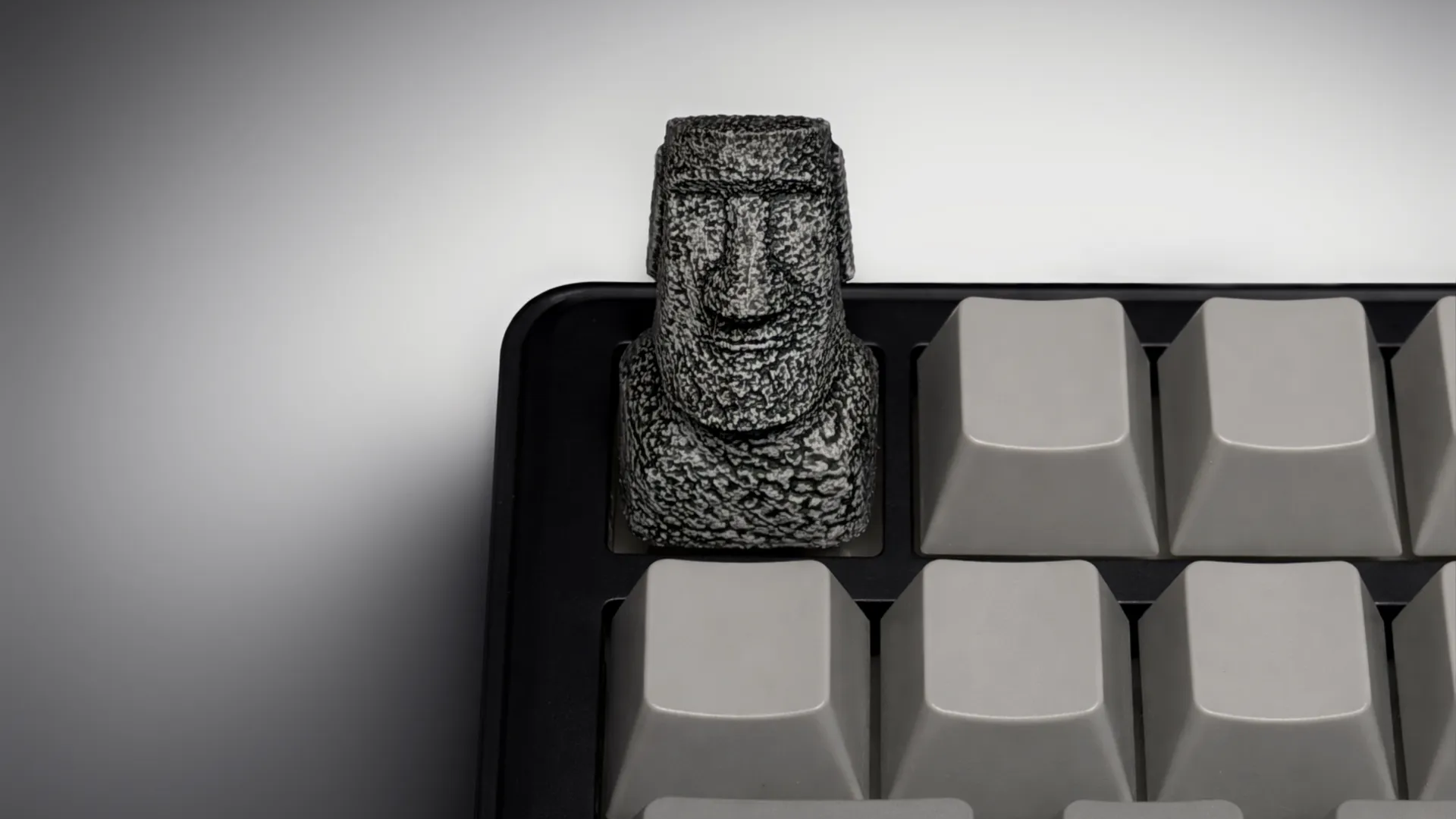 XIIX Moai Ancient Stone artisan keycap on a grey mechanical keyboard, front view