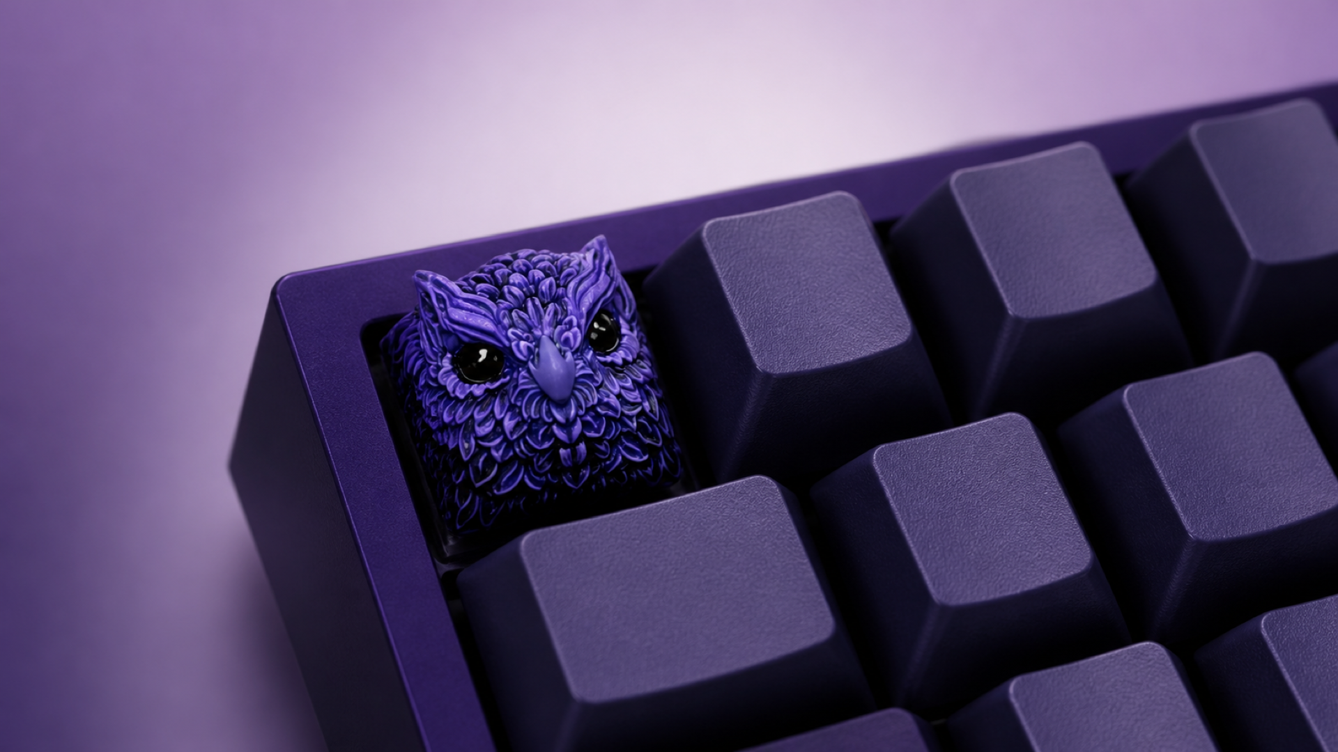 XIIX Owl Indigo artisan keycap on an indigo mechanical keyboard, front three-quarter view