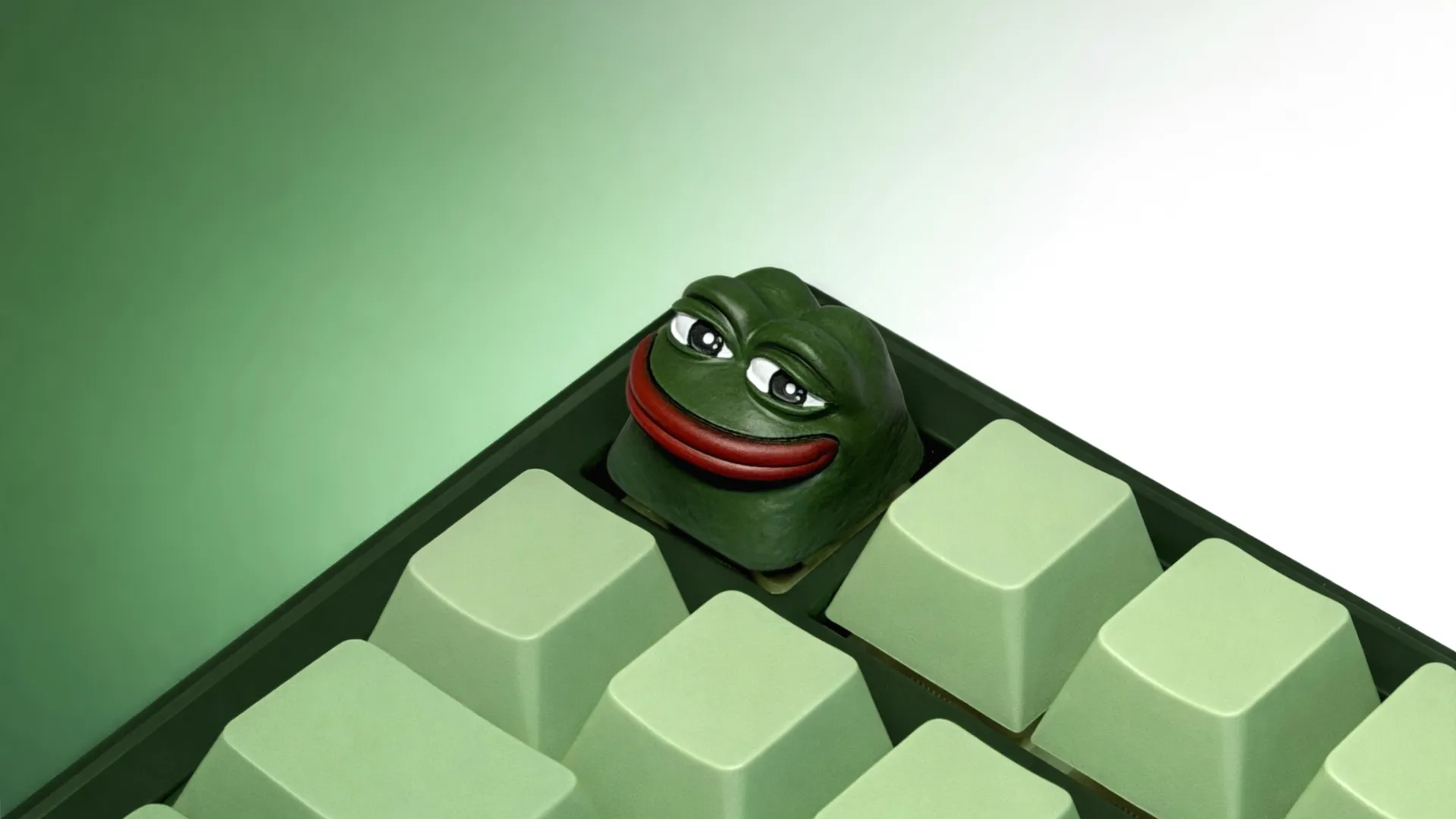 XIIX Pepe the Frog artisan keycap on a green mechanical keyboard, angled view